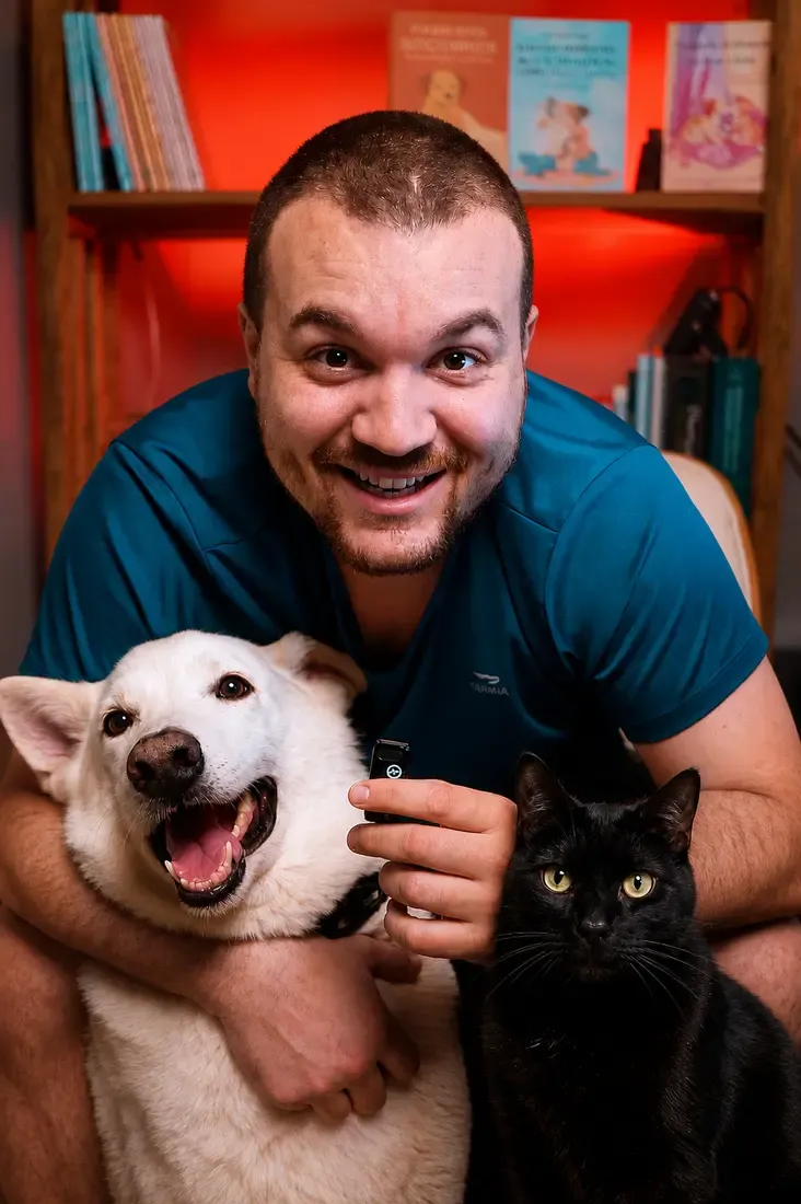 Victor abraçando o cão branco e o gato preto do projeto